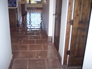 After cleaning, this Mexican tile floor is restored to its original glossy sheen, even to the point of reflecting celing lights