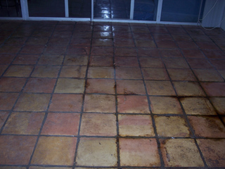 Before cleaning, the tiles of this  floor were discolored, the grout a dark brown and black