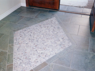 Desert Tile & Grout Care examines this dirty stone tile floor