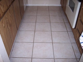 The dark brown grout in this tile floor in Gilbert Arizona is actually supposed to be white in color