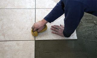 man installing tile and grout in his phoenix home